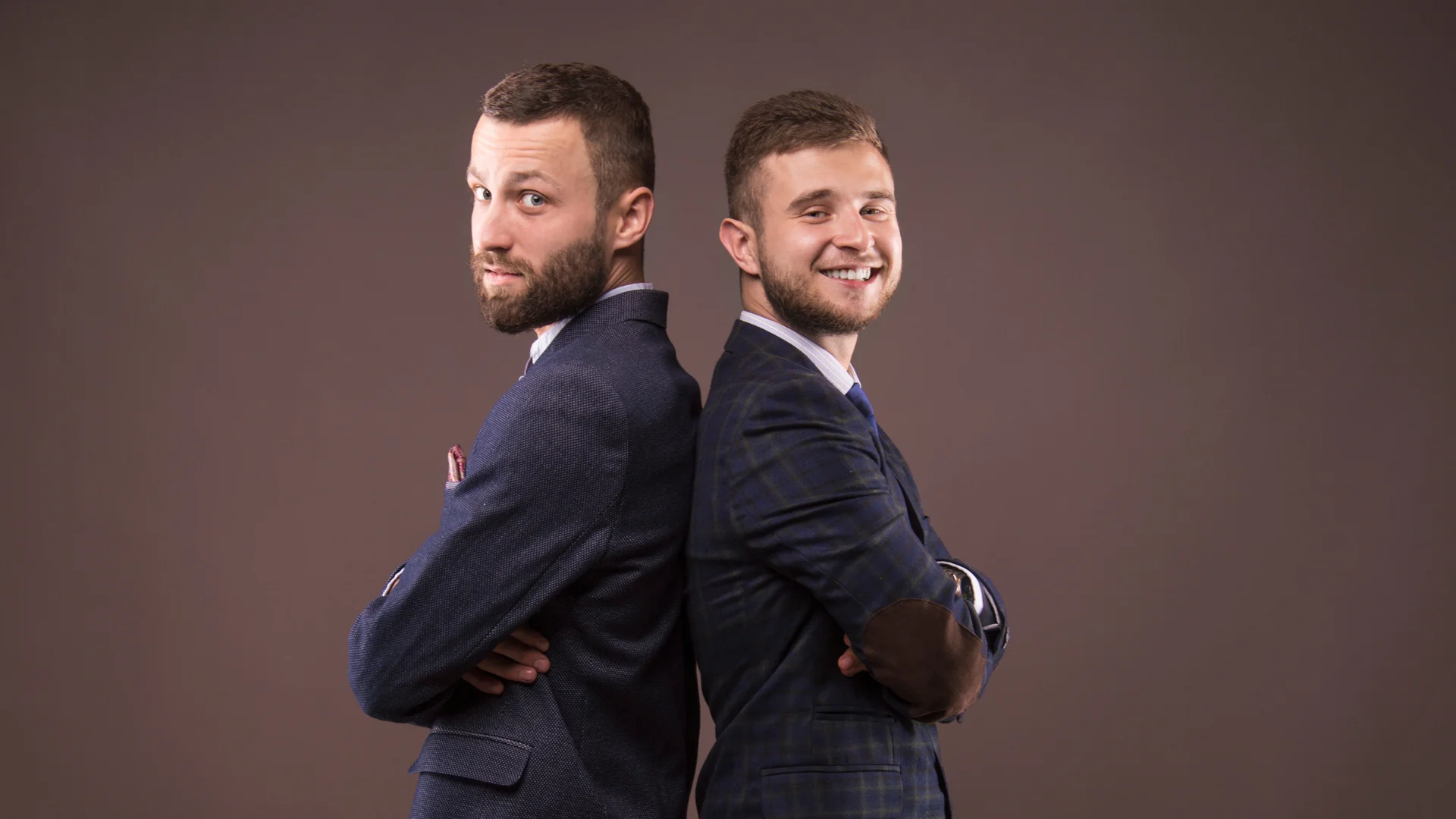 Deux hommes en costumes de commerciaux dos à dos, représentant un apporteur d'affaire et agent commercial